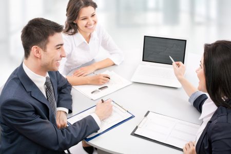 Three workers discussing with a laptop